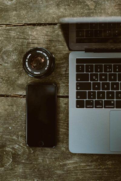 camera lens and laptop on table